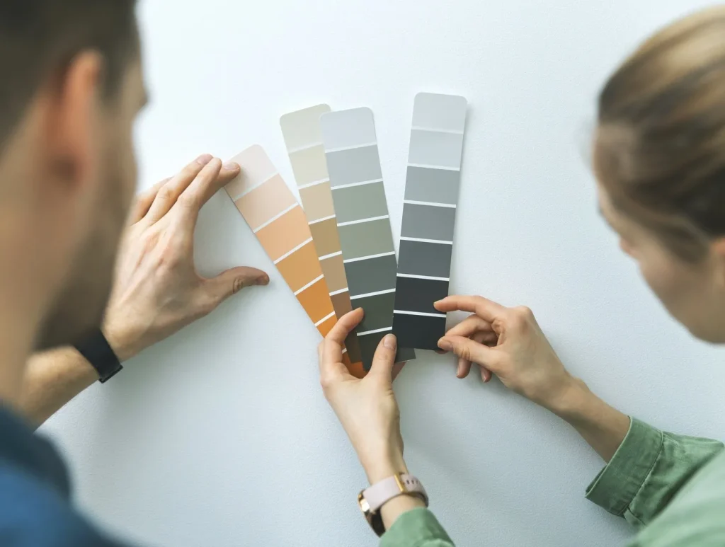 Person holding paint roller while painting the wall